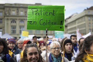 Les physiothérapeutes et des patients ont manifesté contre les projets du Conseil fédéral vendredi à Berne. KEYSTONE/PETER KLAUNZER